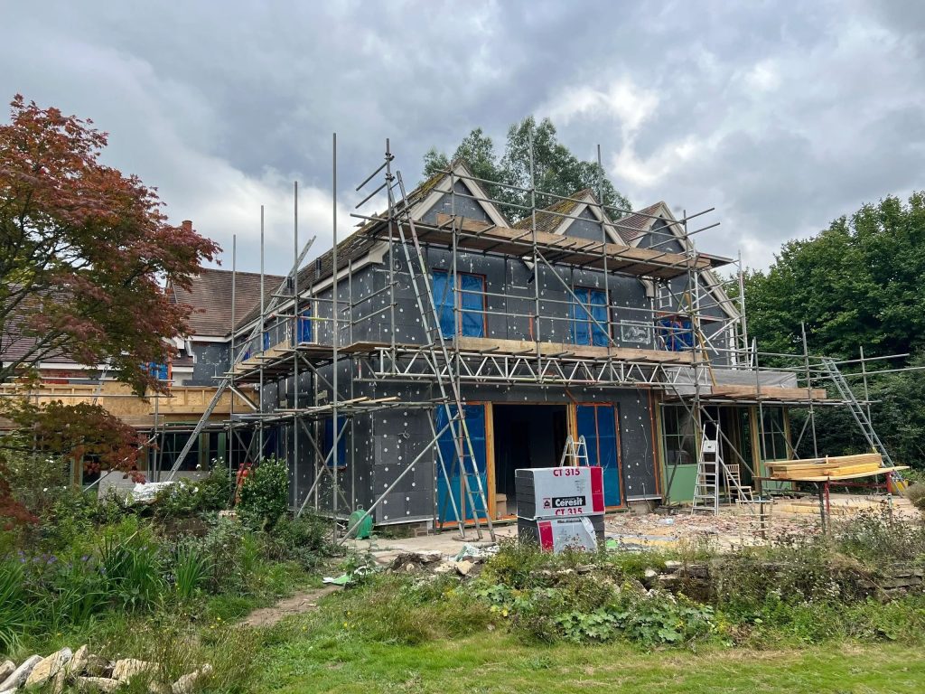 Insulation boards fixed to a house exterior with scaffolding in place