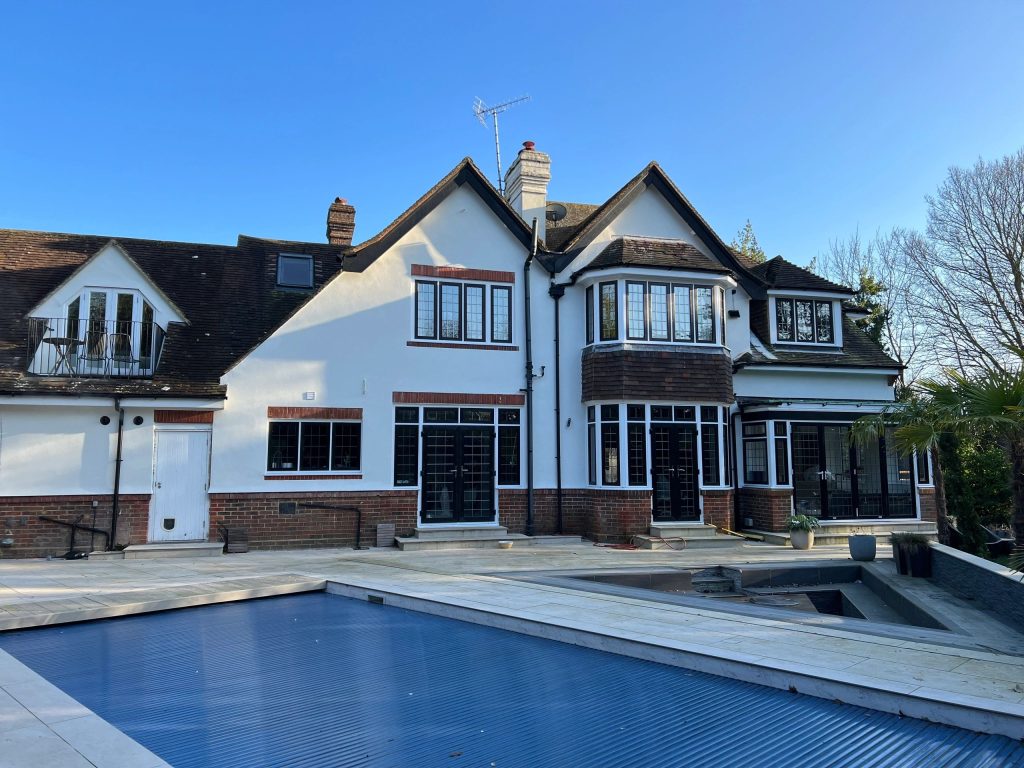 Large white rendered house with a swimming pool